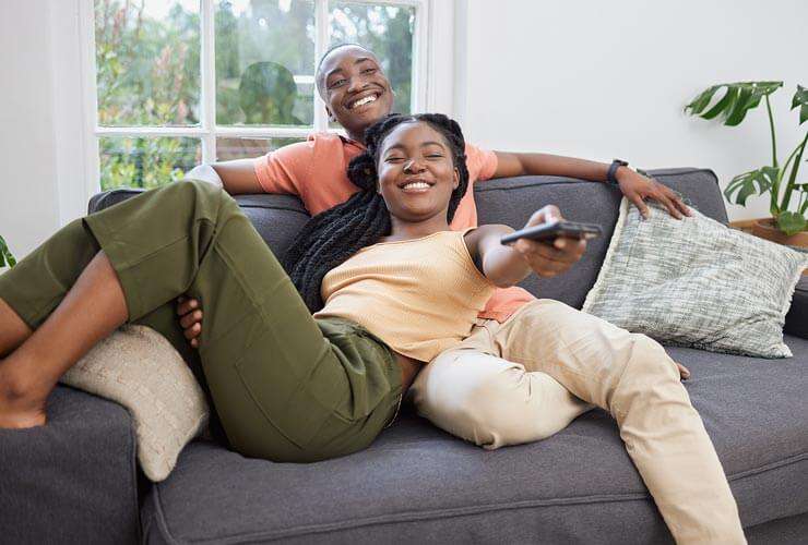 Couple watches TV with remote
